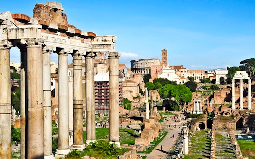 Ancient Roman Forum ruins with Colosseum in the background, Rome scooter tour.