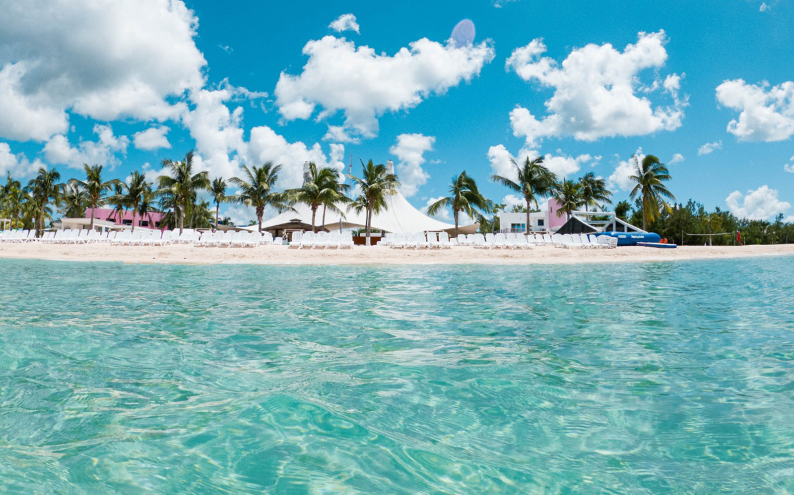 Cozumel Island beach with palm trees and clear water, part of snorkeling tour.