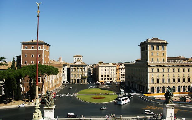 Piazza Venezia in Rome with historic buildings and traffic, viewed from above.