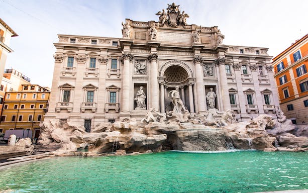 Trevi Fountain in Rome with baroque sculptures and turquoise water.