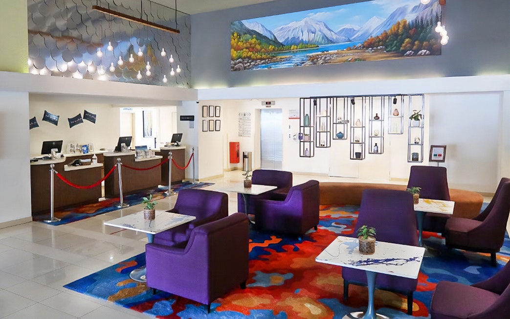 Hotel lobby with colorful seating and artwork, part of Water World @ i-City Shah Alam package.