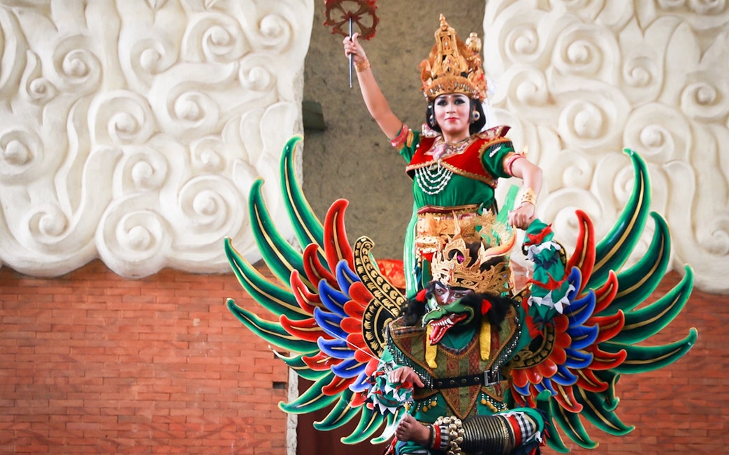 Traditional Balinese performer in colorful costume at Garuda Wisnu Kencana Culture Park, Bali.