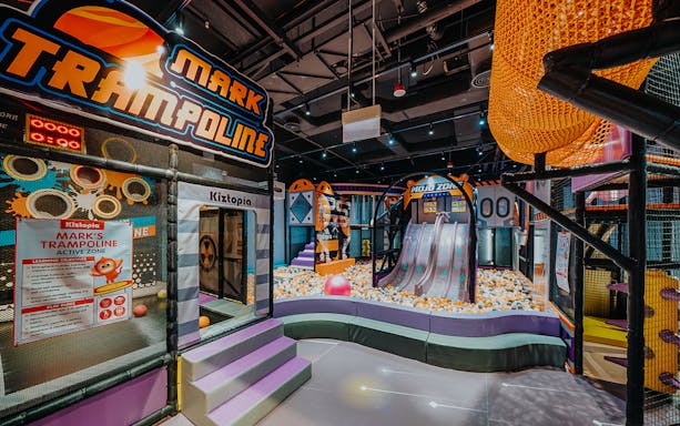 Indoor playground at Kiztopia Club Jurong Point featuring slides, trampolines, and ball pit.