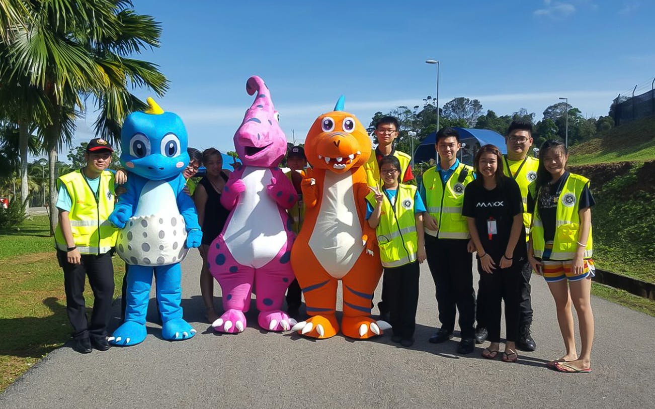 Group with dinosaur mascots at Melaka Wonderland Water Theme Park.