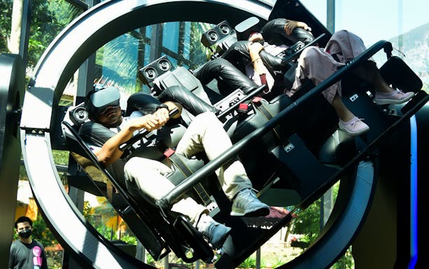 Visitors experiencing a VR ride at VR Universal with headsets and motion seats.