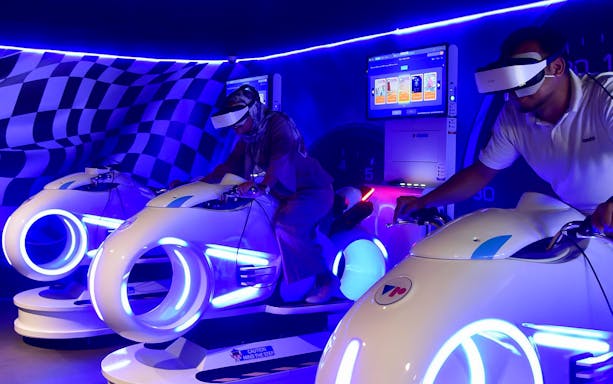 Visitors using VR motorbike simulators at VR Universal.