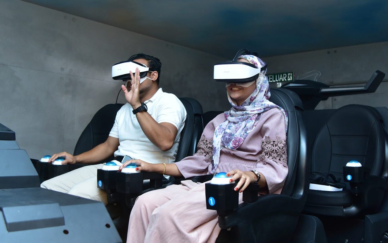 Visitors enjoying VR experience at VR Universal with headsets and controls.