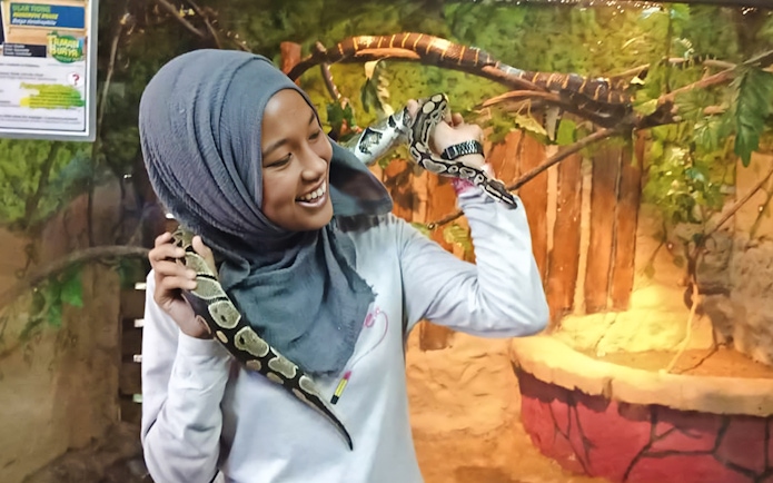 Person holding a snake at Melaka Crocodile & Recreational Park.