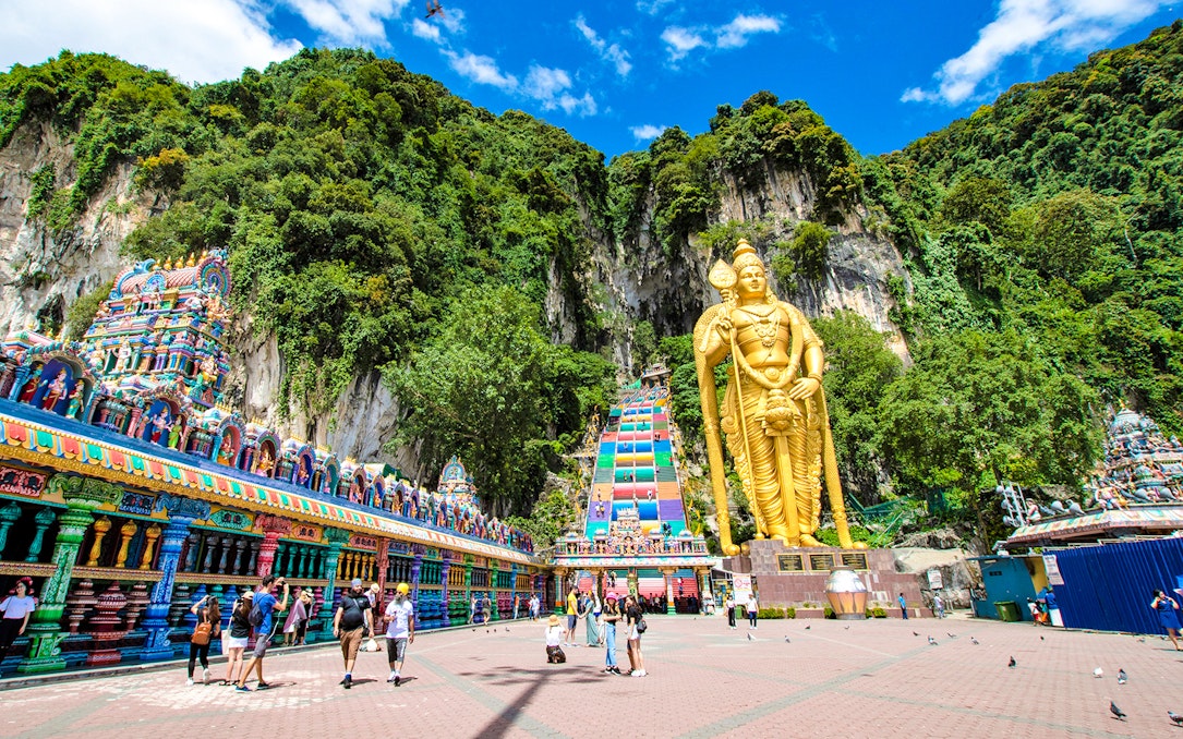 Batu Caves entrance with golden Lord Murugan statue and colorful temple facade in Kuala Lumpur.