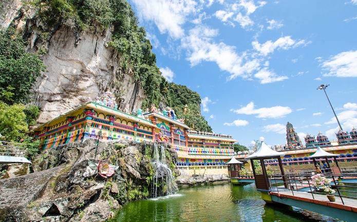 Batu Caves temple complex with colorful facade and surrounding limestone cliffs in Kuala Lumpur.