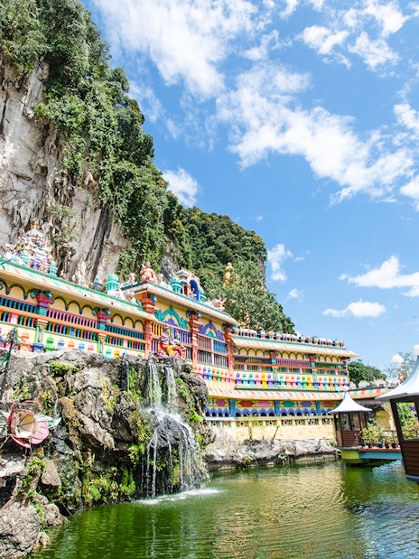 Batu Caves temple complex with colorful facade and surrounding limestone cliffs in Kuala Lumpur.