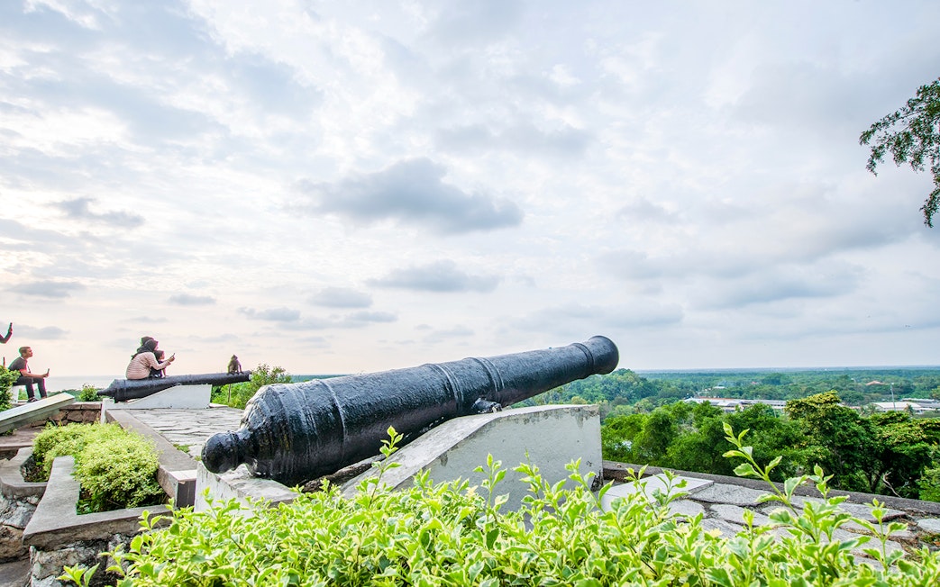 Historic cannon overlooking lush landscape on Kuala Lumpur and Batu Caves tour.