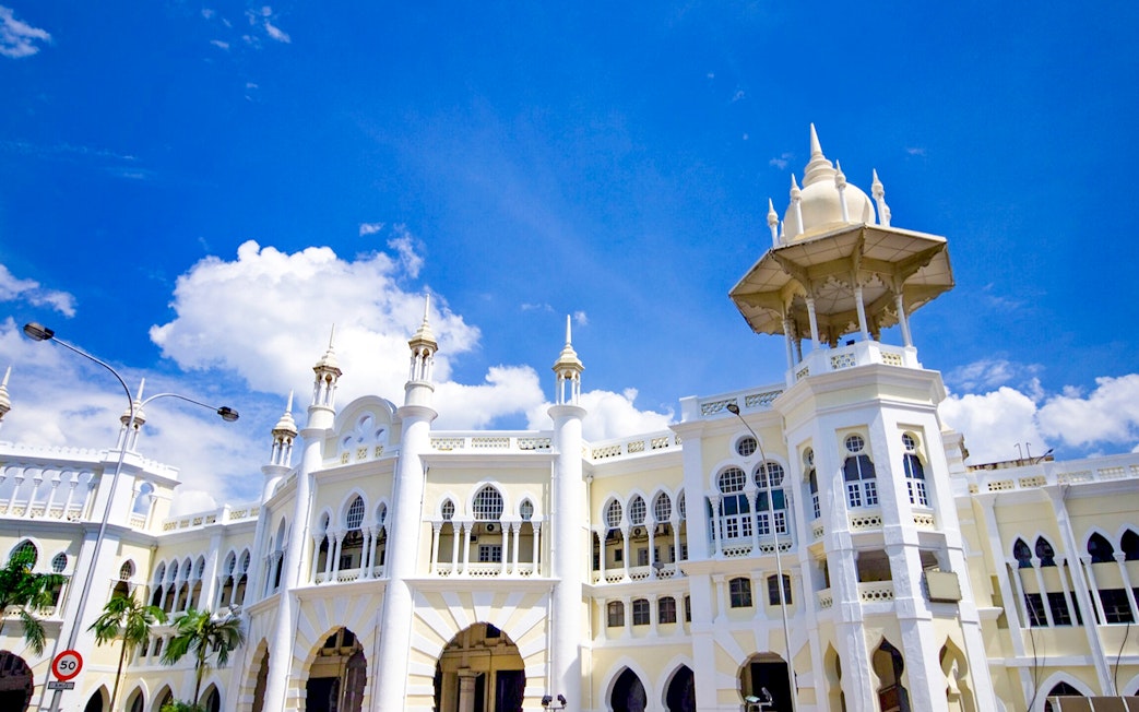 Kuala Lumpur Railway Station with Moorish architecture under blue sky.