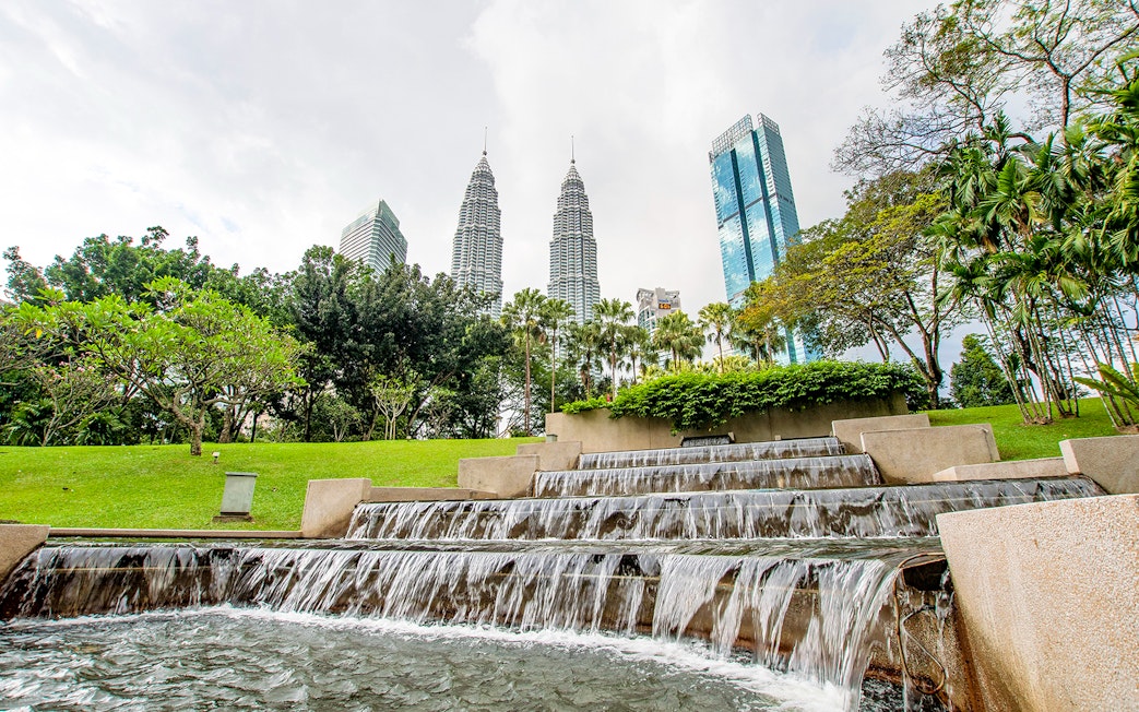 Petronas Towers and park waterfall in Kuala Lumpur, Malaysia.