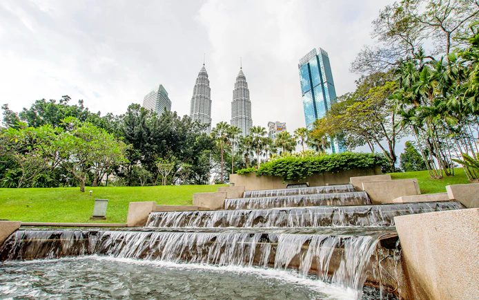 Petronas Towers and park waterfall in Kuala Lumpur, Malaysia.