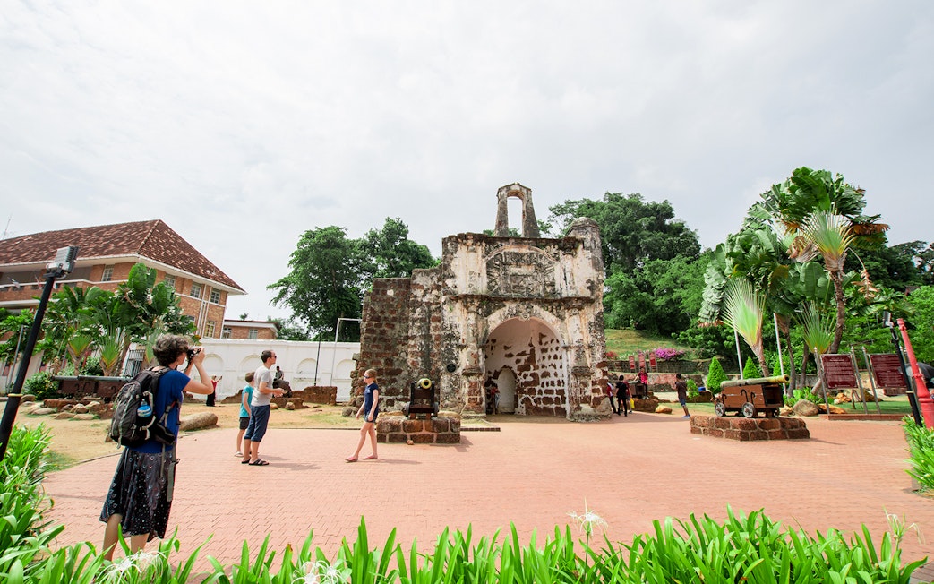 A Famosa fortress ruins with tourists exploring in Melaka, Malaysia.