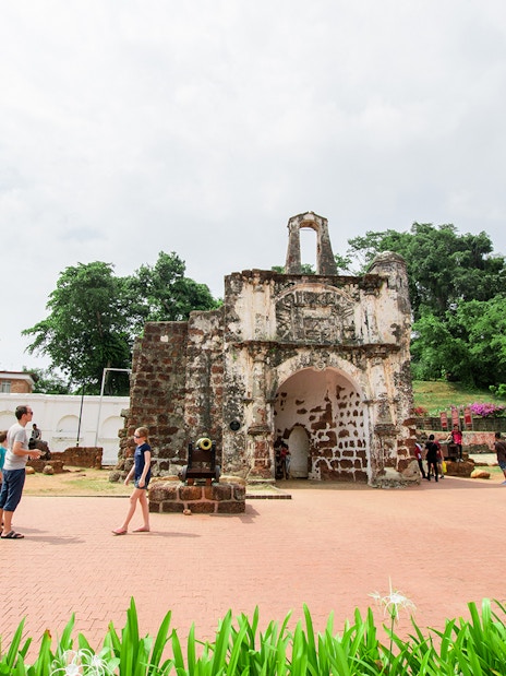 A Famosa fortress ruins with tourists exploring in Melaka, Malaysia.