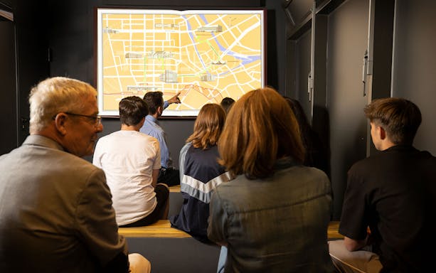 Visitors viewing a map during the Berlin TimeRide VR time travel experience.