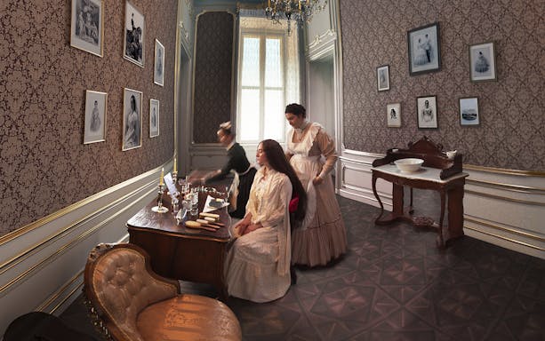 Women in period clothing in a Schönbrunn Palace room during a virtual tour.