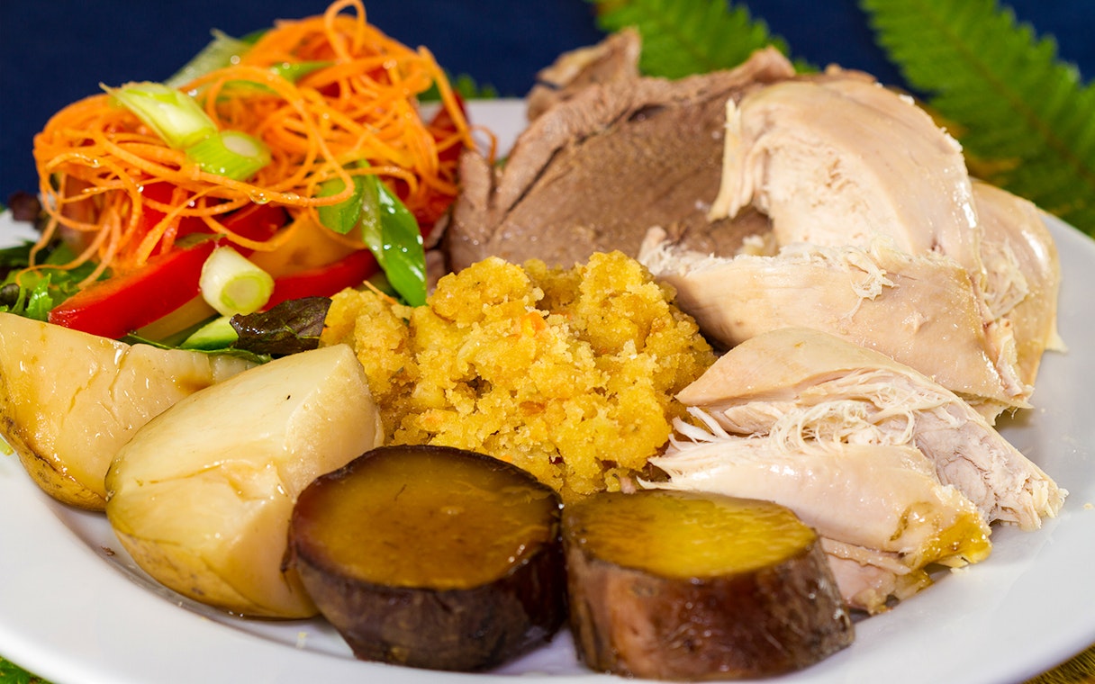 Traditional Maori feast with roast meats, vegetables, and salad at Mitai Maori Cultural Experience.