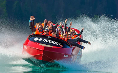 Jetboat with passengers on Lake Brienz, Switzerland, creating water spray.