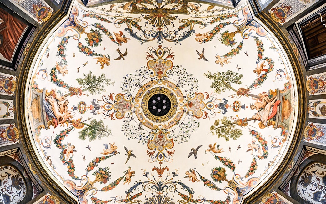 Ornate ceiling fresco at Mozarthouse concert venue, featuring cherubs and floral motifs.