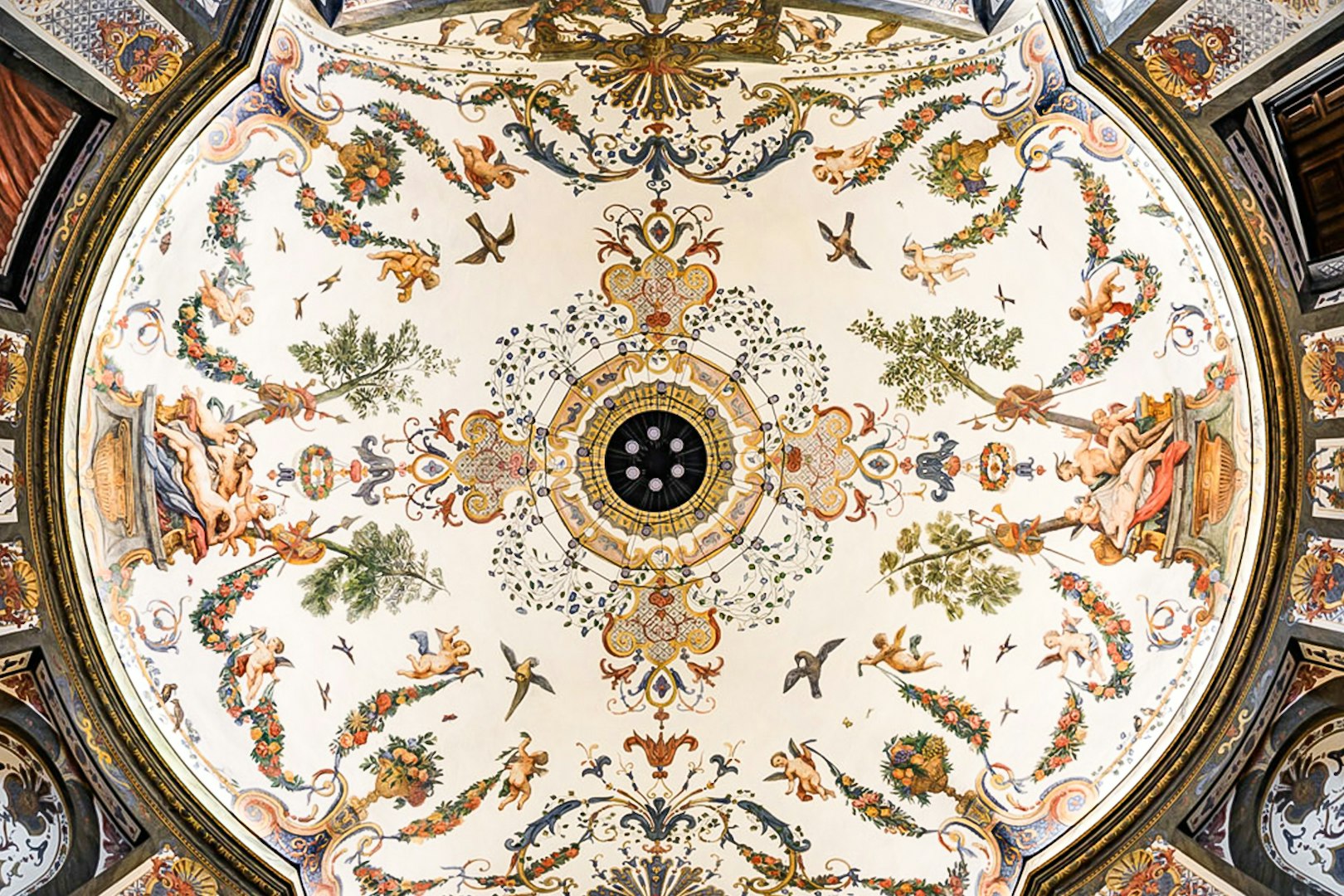 Ornate ceiling fresco at Mozarthouse concert venue, featuring cherubs and floral motifs.