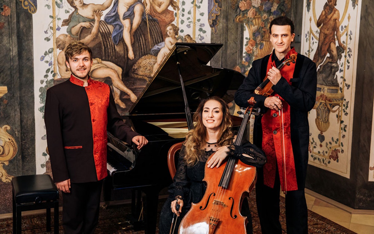 Musicians with piano, cello, and violin at Mozarthouse concert.