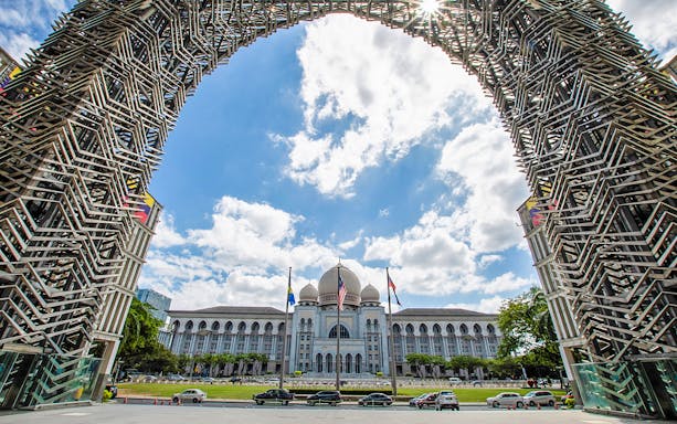 Putrajaya Palace of Justice framed by intricate metal arch, Malaysia.