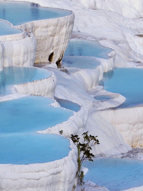 Pamukkale thermal terraces with blue water in Turkey.