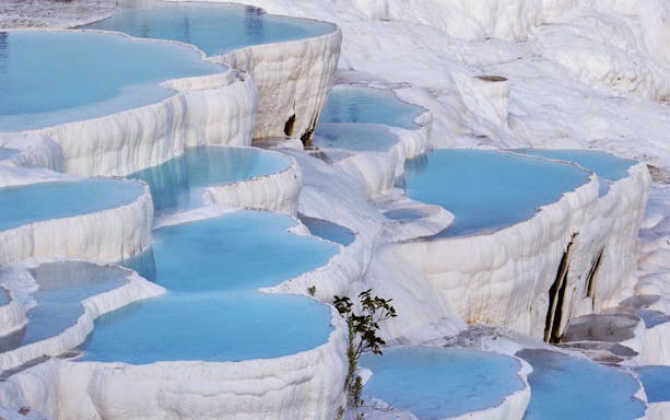 Pamukkale thermal terraces with blue water in Turkey.
