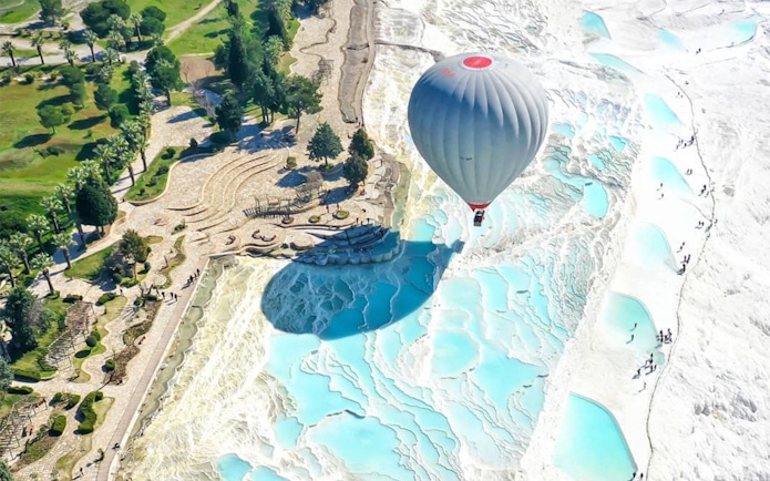 Hot air balloon over Pamukkale's travertine terraces, Turkey, during Antalya/Kemer tour.
