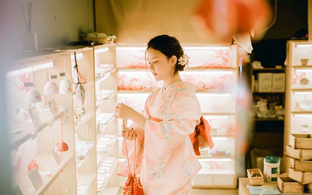 Woman in a kimono browsing a shop in Tokyo.