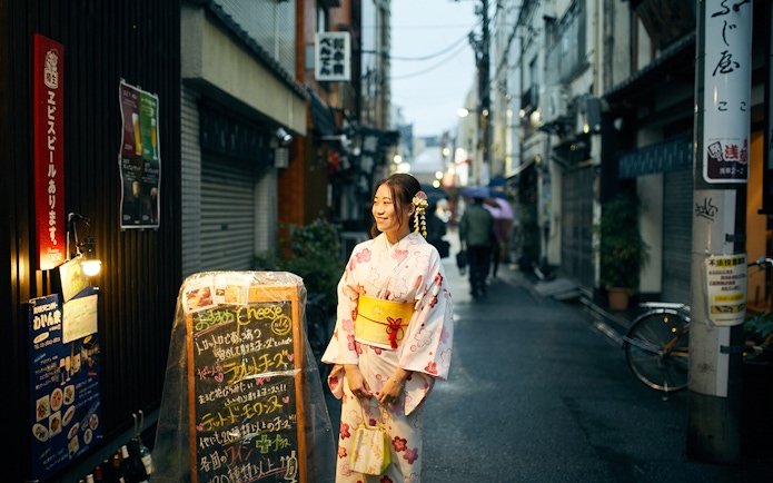 Woman in kimono standing on a street in Tokyo, Japan.