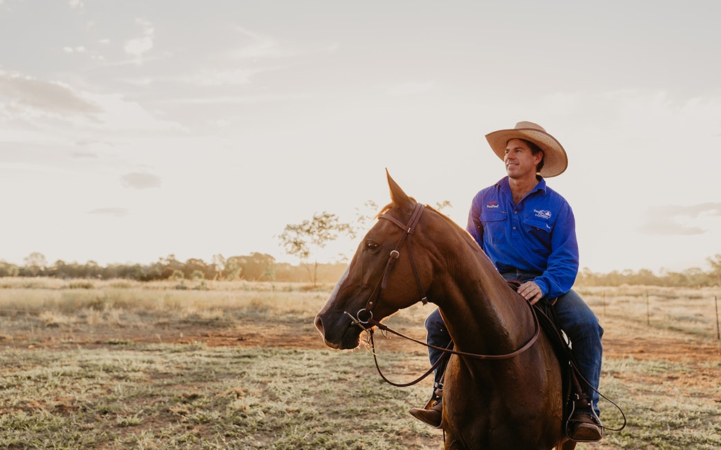 Horse rider in blue shirt at Katherine Outback Experience, Australia.