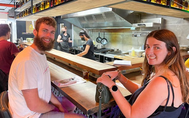 Couple enjoying a culinary experience at a Wellington restaurant kitchen counter.