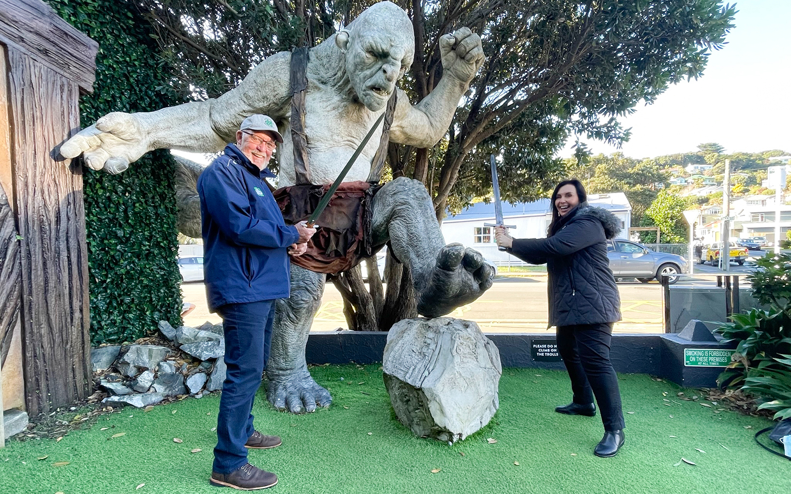 Visitors posing with a troll statue during a private tour in Wellington.