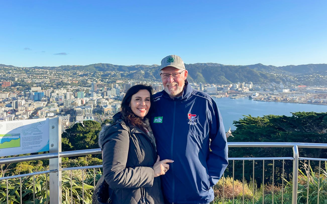 Couple enjoying the view of Wellington city and harbor from a scenic lookout.