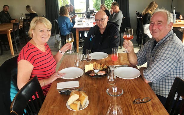 Guests enjoying wine and cheese at a Martinborough winery tour.