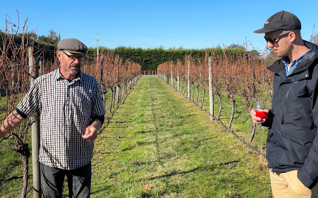 Winemaker discussing vineyard with visitor on A Taste of Martinborough tour.