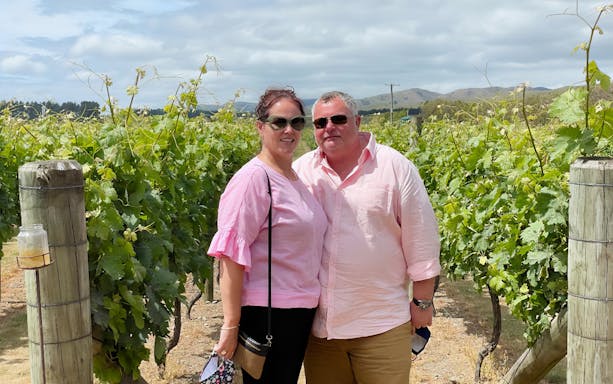 Couple standing in a Martinborough vineyard during the Wine Delights Tour.