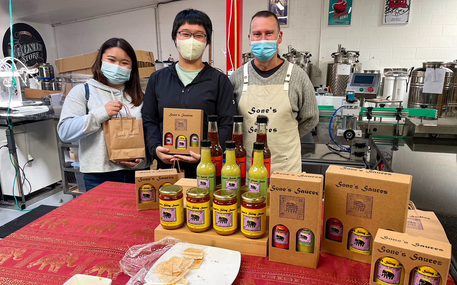 Visitors at Sone's Sauces shop on Kāpiti Coast food tour, showcasing local products.