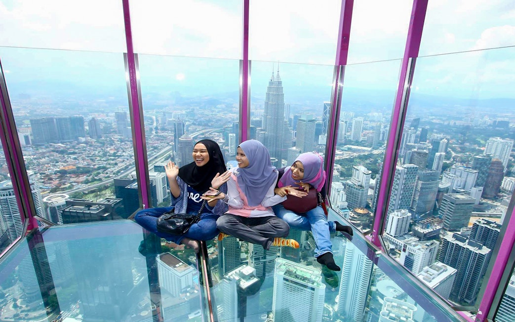Visitors enjoying the view from the Sky Box at KL Tower, Kuala Lumpur, Malaysia.