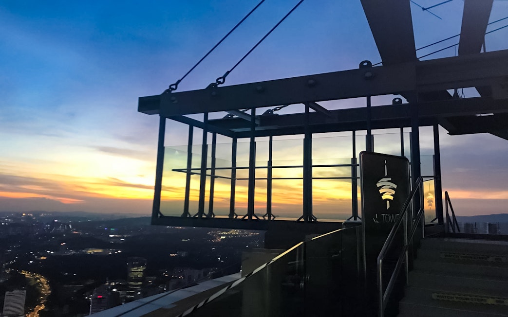 KL Tower Sky Box at sunset, overlooking Kuala Lumpur cityscape.