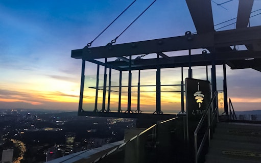 KL Tower Sky Box at sunset, overlooking Kuala Lumpur cityscape.