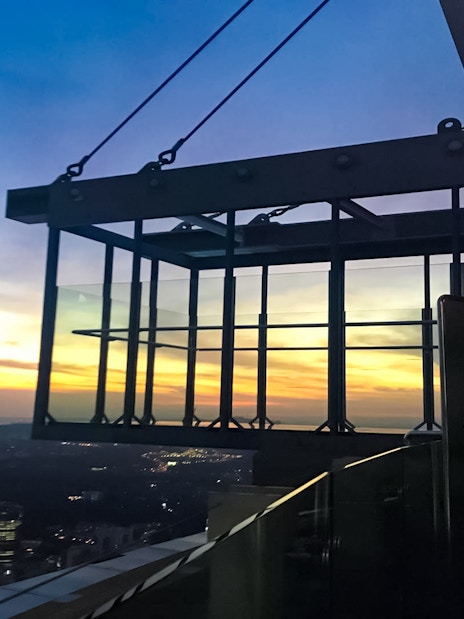 KL Tower Sky Box at sunset, overlooking Kuala Lumpur cityscape.
