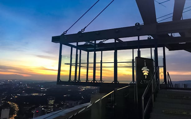 KL Tower Sky Box at sunset, overlooking Kuala Lumpur cityscape.