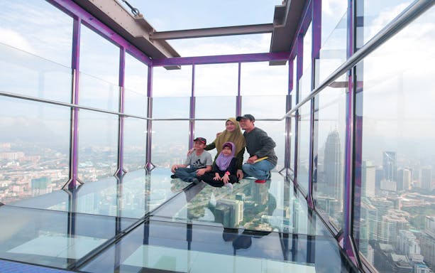 Family enjoying the view from the Sky Box at KL Tower, Malaysia.