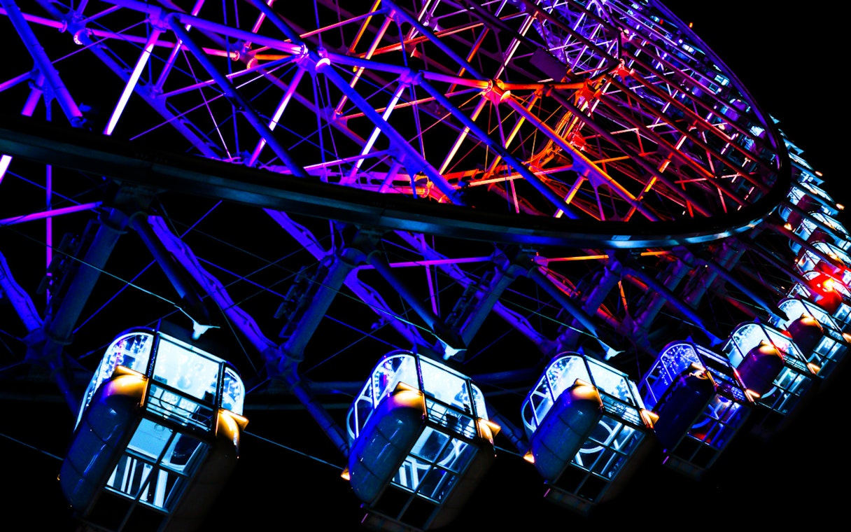Colorful illuminated cabins of Redhorse Osaka Wheel at night.