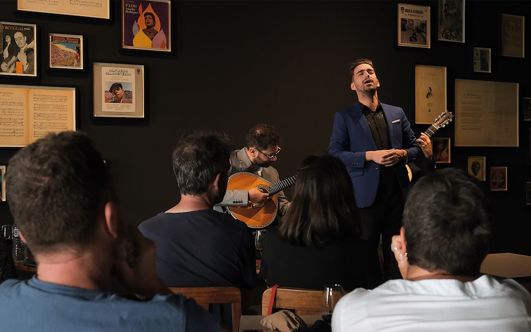 Fado performance with singer and guitarist in Porto venue.